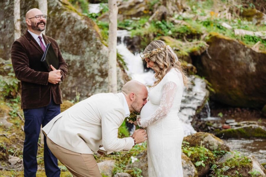 kissing belly at a waterfall with elope outdoors