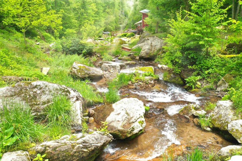 Creekside waterfall landscape at Weddings Over Waterfalls with layered rock formations, flowing water, and a quiet, nature-filled atmosphere.