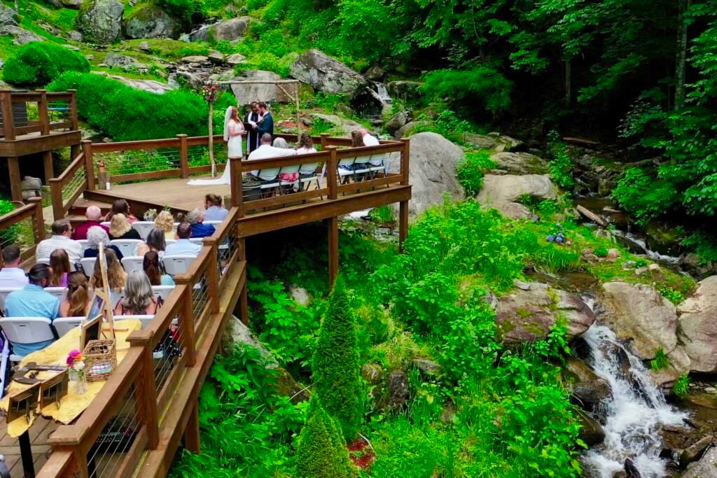 Scenic waterfall wedding setting with lush greenery and boulder-lined creek at Weddings Over Waterfalls, an intimate outdoor wedding venue in the mountains of North Carolina.
